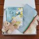 Mc Nutt My First Blanket Gift Set in blue featuring a fringed baby blanket with colorful stripes, plush teddy bear, and ‘The Children of Lir’ storybook – thoughtful newborn gift box. Mc Nutt My First Blanket Gift Set in blue featuring a fringed baby blanket with colorful stripes, plush teddy bear, and ‘The Children of Lir’ storybook – thoughtful newborn gift box.
